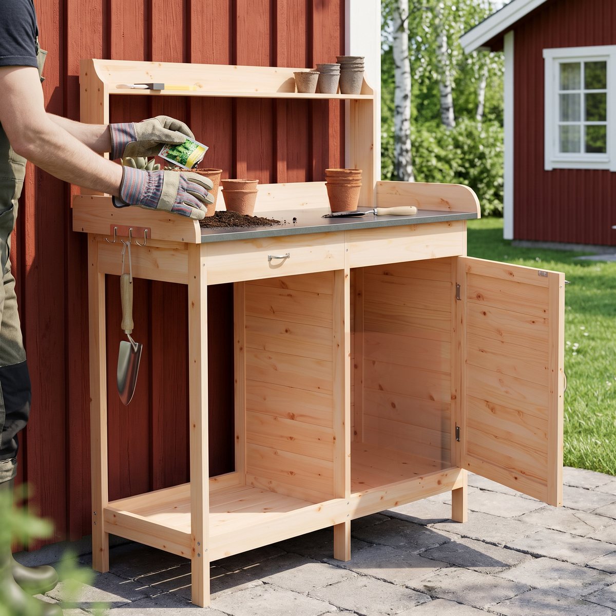 Odlingsbänk med skåp i granträ mot en faluröd bodvägg, där någon i trädgårdshandskar sår frön i små krukor