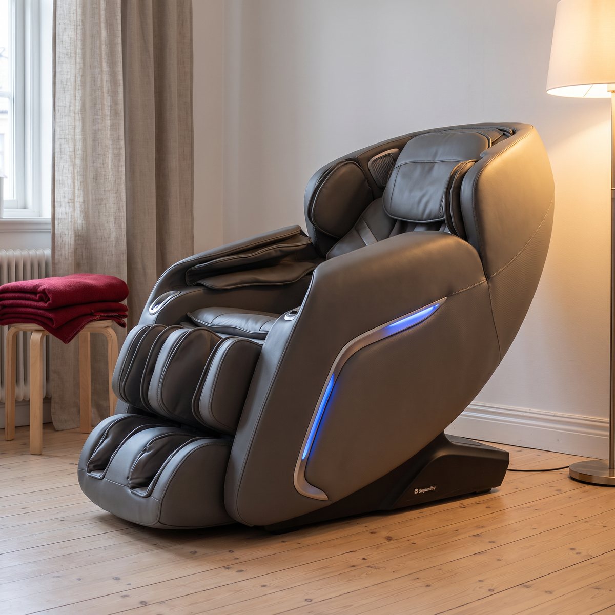 Grå massagestol med ljusslinga i sidan i ett svenskt vardagsrum med furugolv och lampa