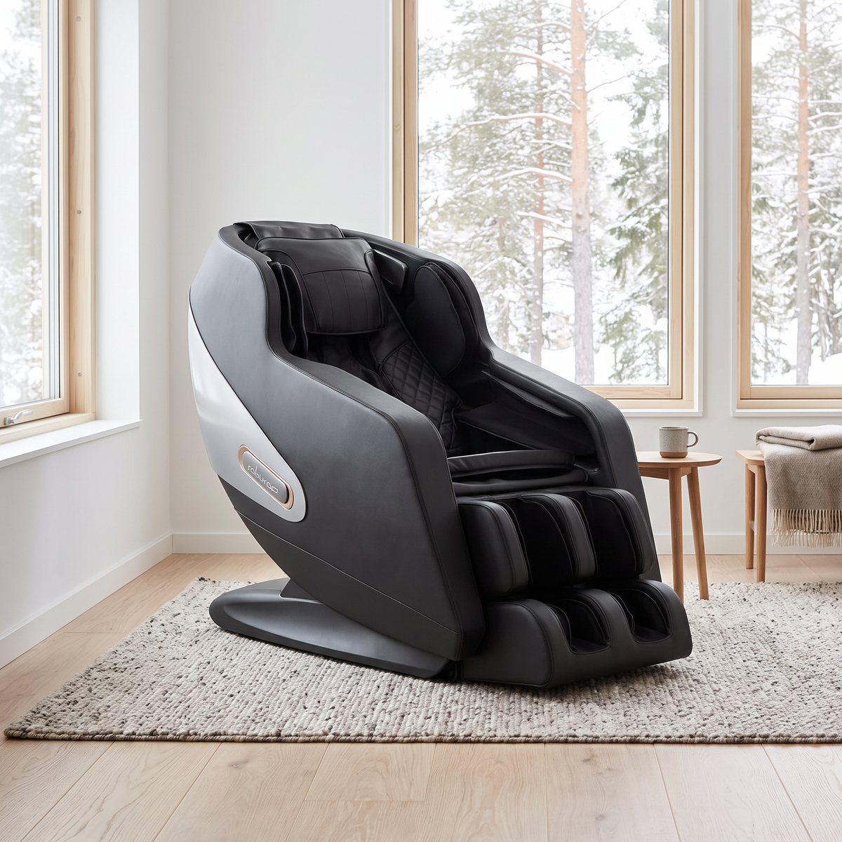 Svart massagestol med silvergrå sidopanel i ett ljust svenskt vardagsrum med ekgolv och snötäckta tallar utanför fönstret