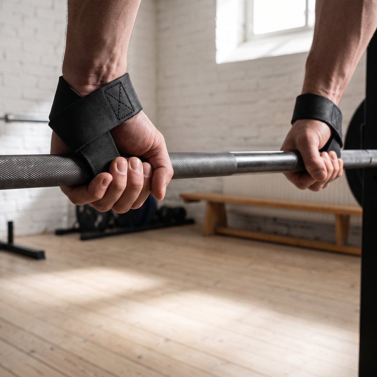 Svarta dragremmar i läder runt en skivstång i ett svenskt källargym
