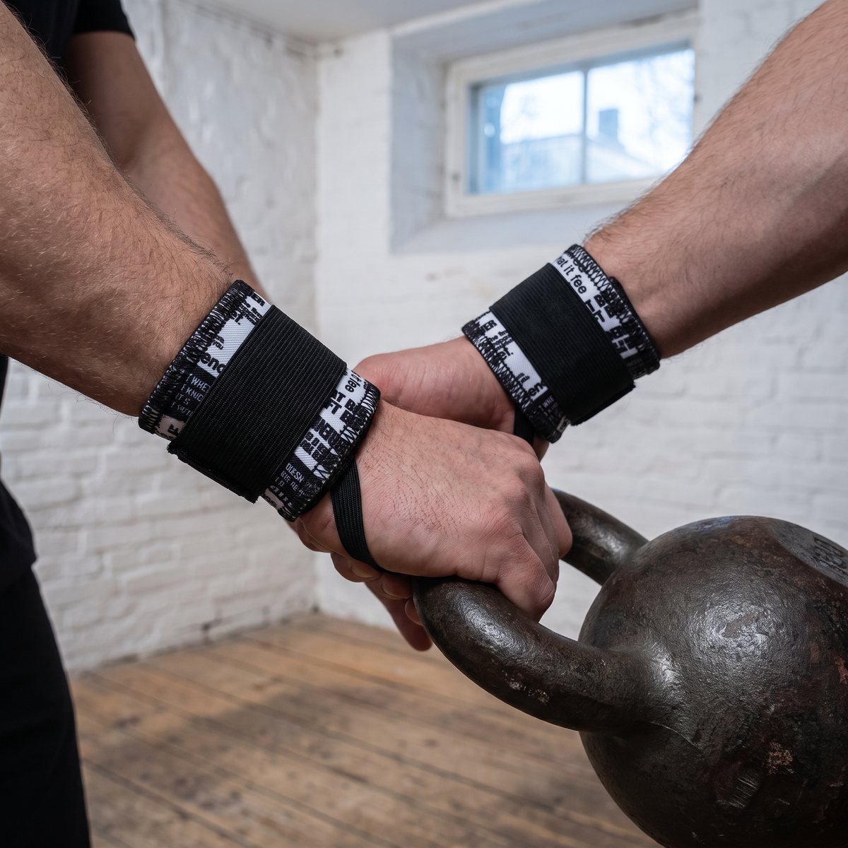 Svartvita handledsstöd på en handled i ett svenskt källargym under kettlebellsving