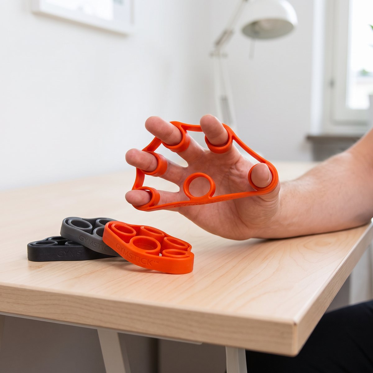 Gymstick Finger Expander Set med spretande fingrar i ett svenskt hemmakontor