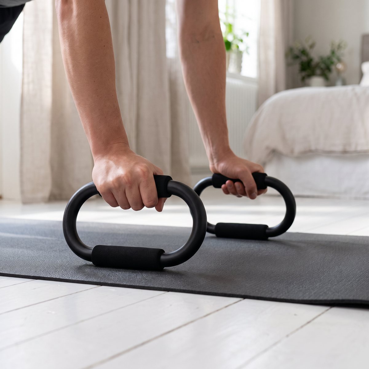Armhävningar med Abilica PushUp Bars på en träningsmatta i ett ljust svenskt sovrum