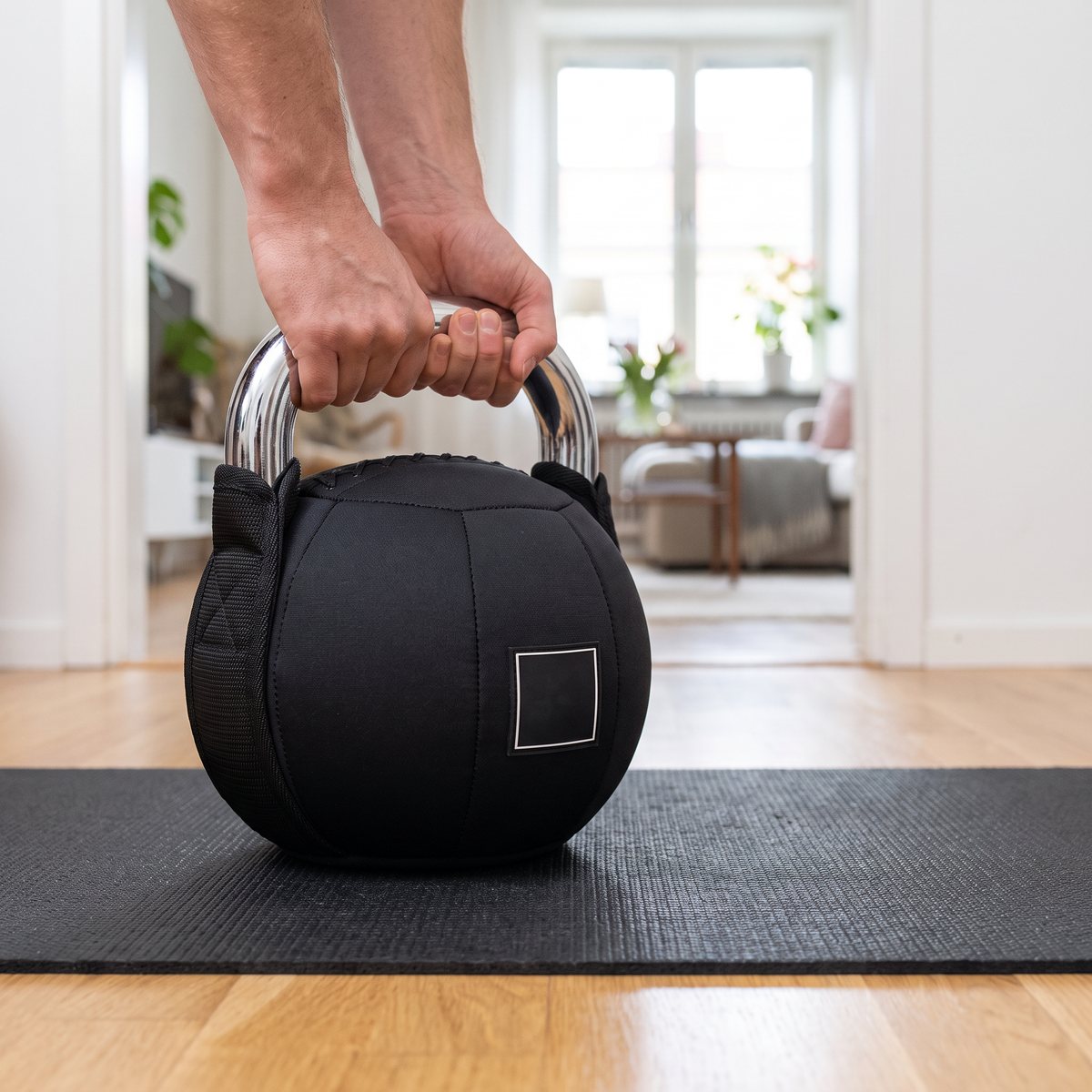Mjuk kettlebell från Master Fitness med kromat handtag och svart tygkula på en matta i en ljus svensk lägenhet