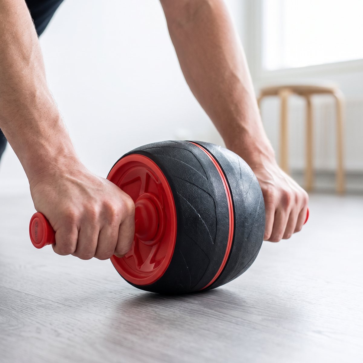 Gymstick Jumbo Ab Roller rullas fram med båda händerna på handtagen i en svensk lägenhet