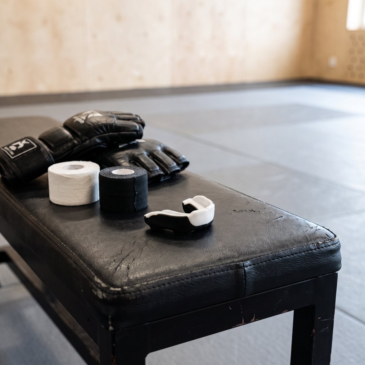 Hammer Ergo Sirius tandskydd i vitt och svart på en bänk i en svensk kampsportslokal