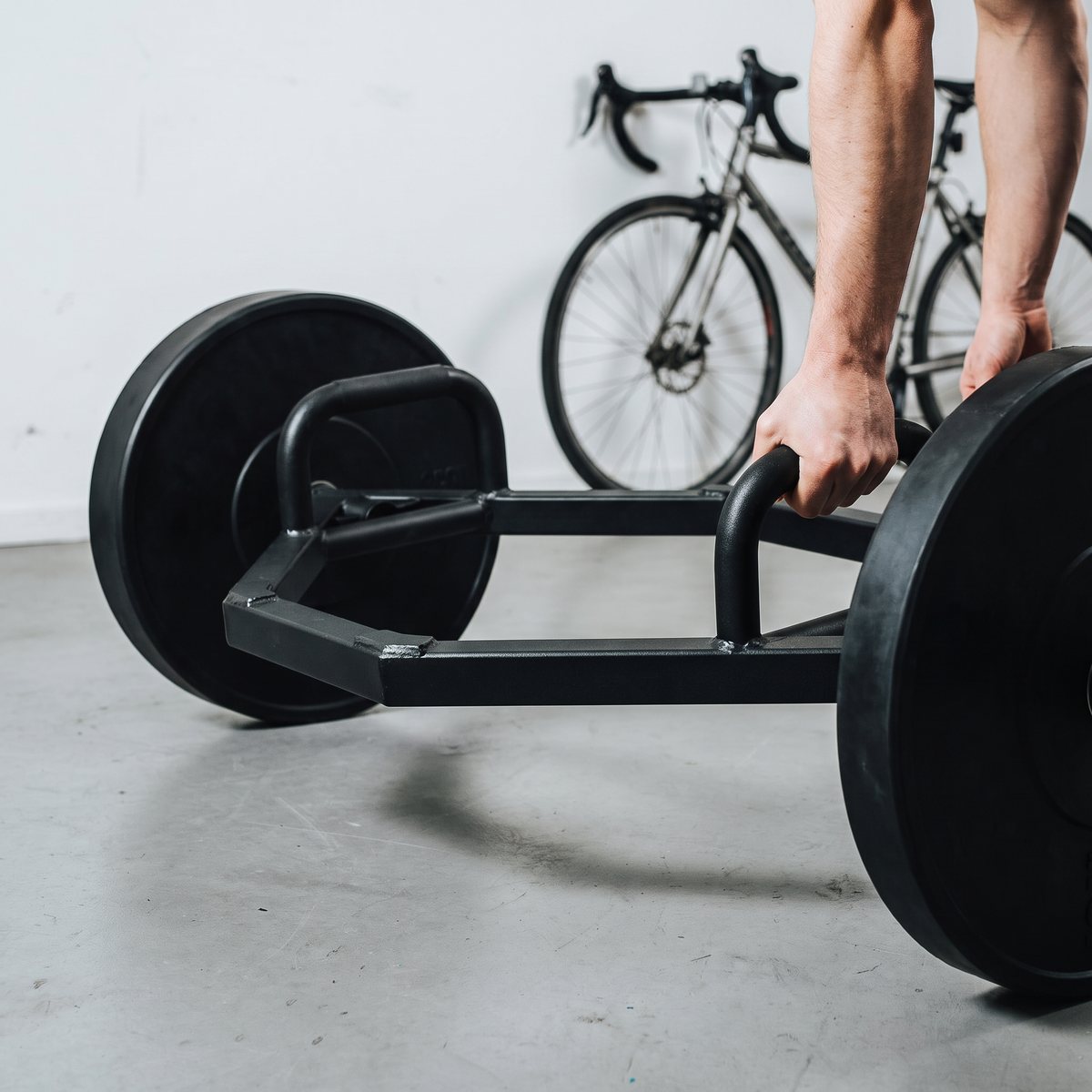 Svart hex-stång med höga handtag på betonggolv i ett svenskt garagegym