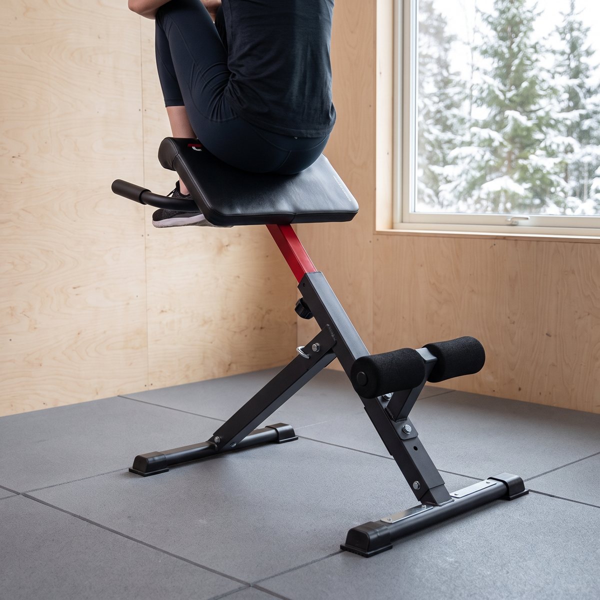 Top Sport AB1000, kombinerad rygg- och magbänk, i ett svenskt hemmagym med plywoodväggar och snötäckta granar utanför fönstret
