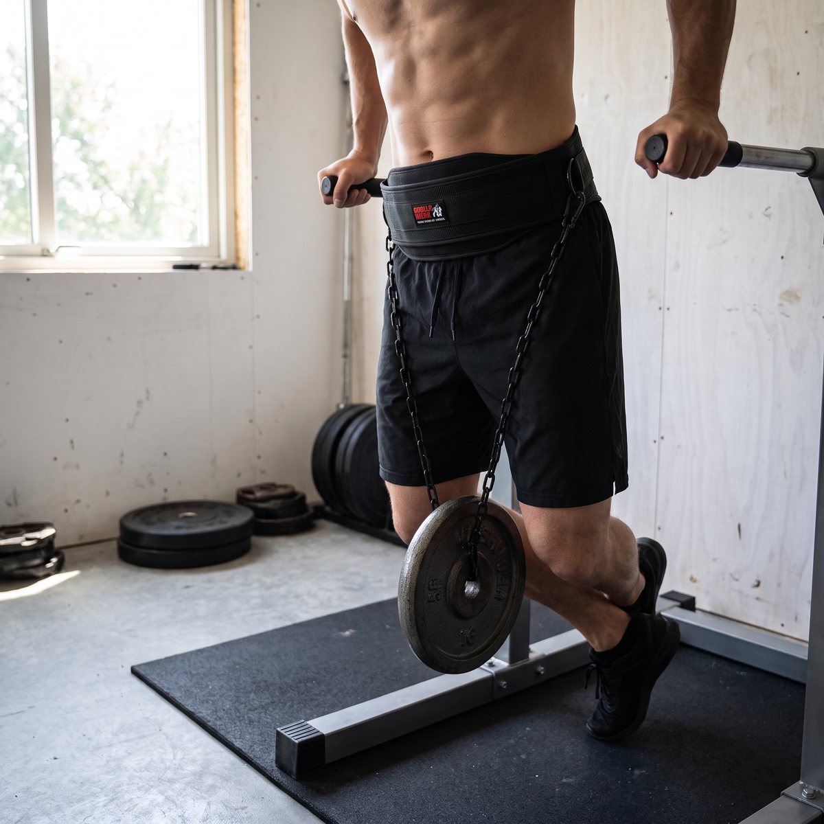 Svart dipbälte i nylon med kedja och viktskiva vid dips i ett svenskt garagegym