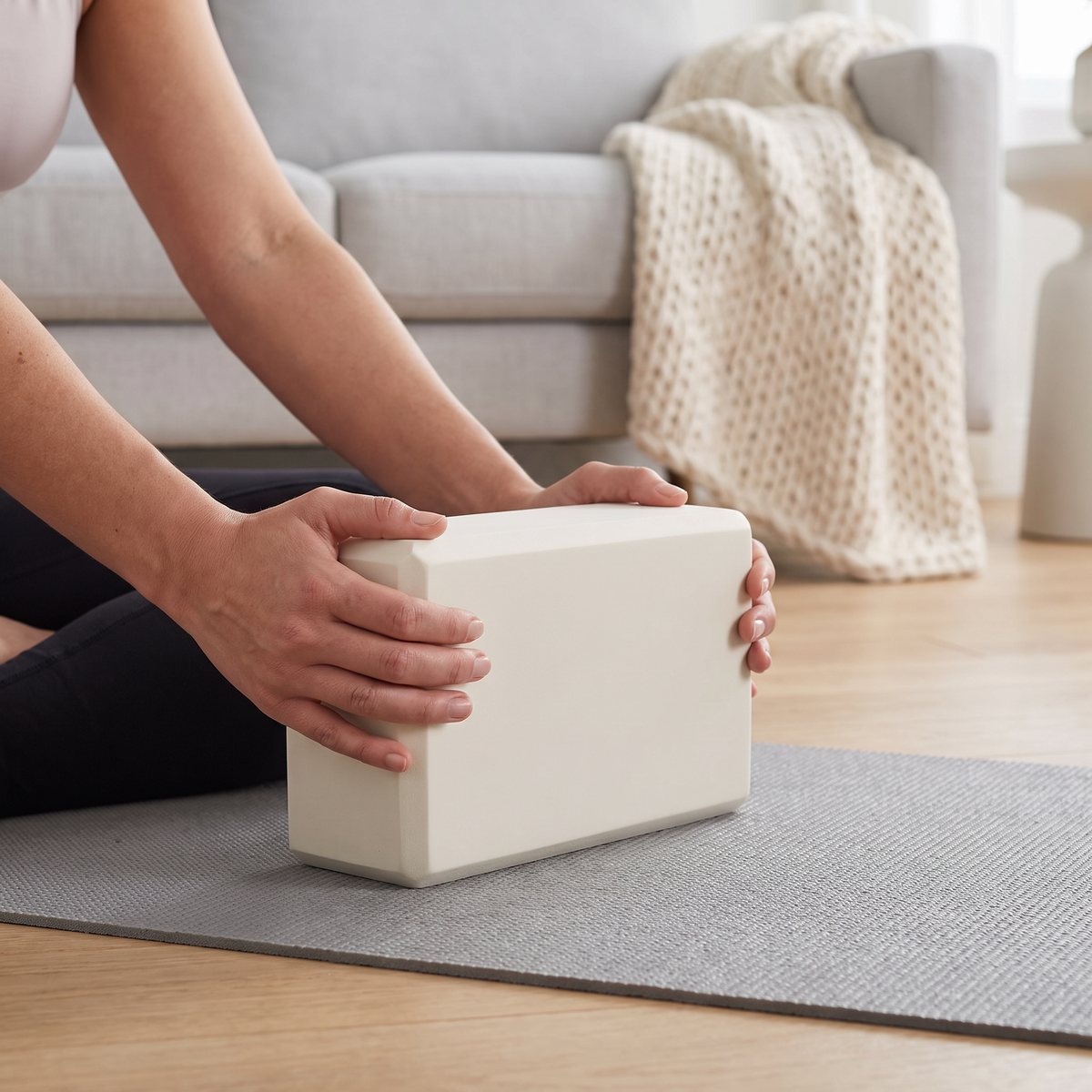 Gaiam yogablock i beige som stöd för händerna vid sittande yoga i ett svenskt vardagsrum