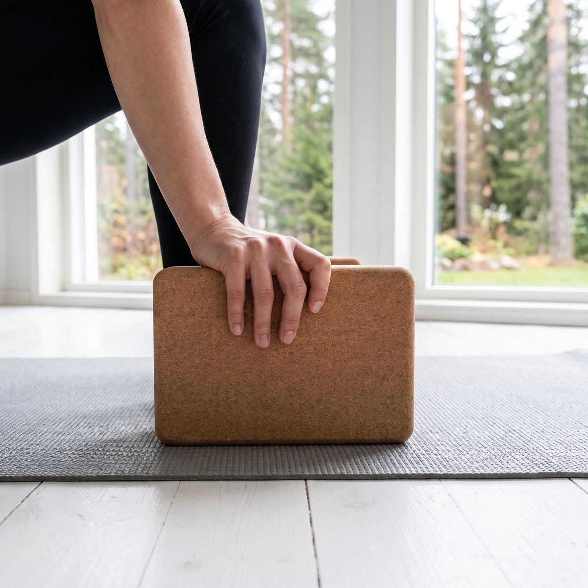 Gymstick korkblock under handen i utfallsställning på yogamatta i ett ljust svenskt hem