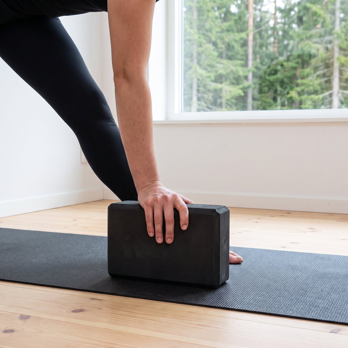 Svart Titan LIFE-yogablock under handen i triangelställning i ett svenskt hemmagym