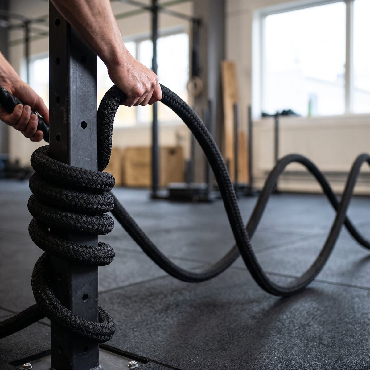 Toorx PRO battle rope i flätat svart rep runt en rigg-stolpe i en svensk crossfitlokal