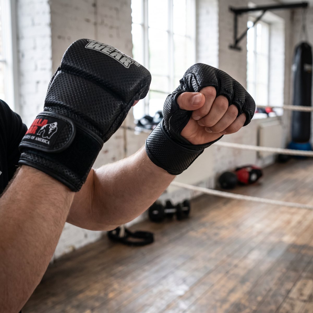 Svarta MMA-sparringhandskar med mönstrad mesh under en sparringrunda i en svensk boxningsklubb