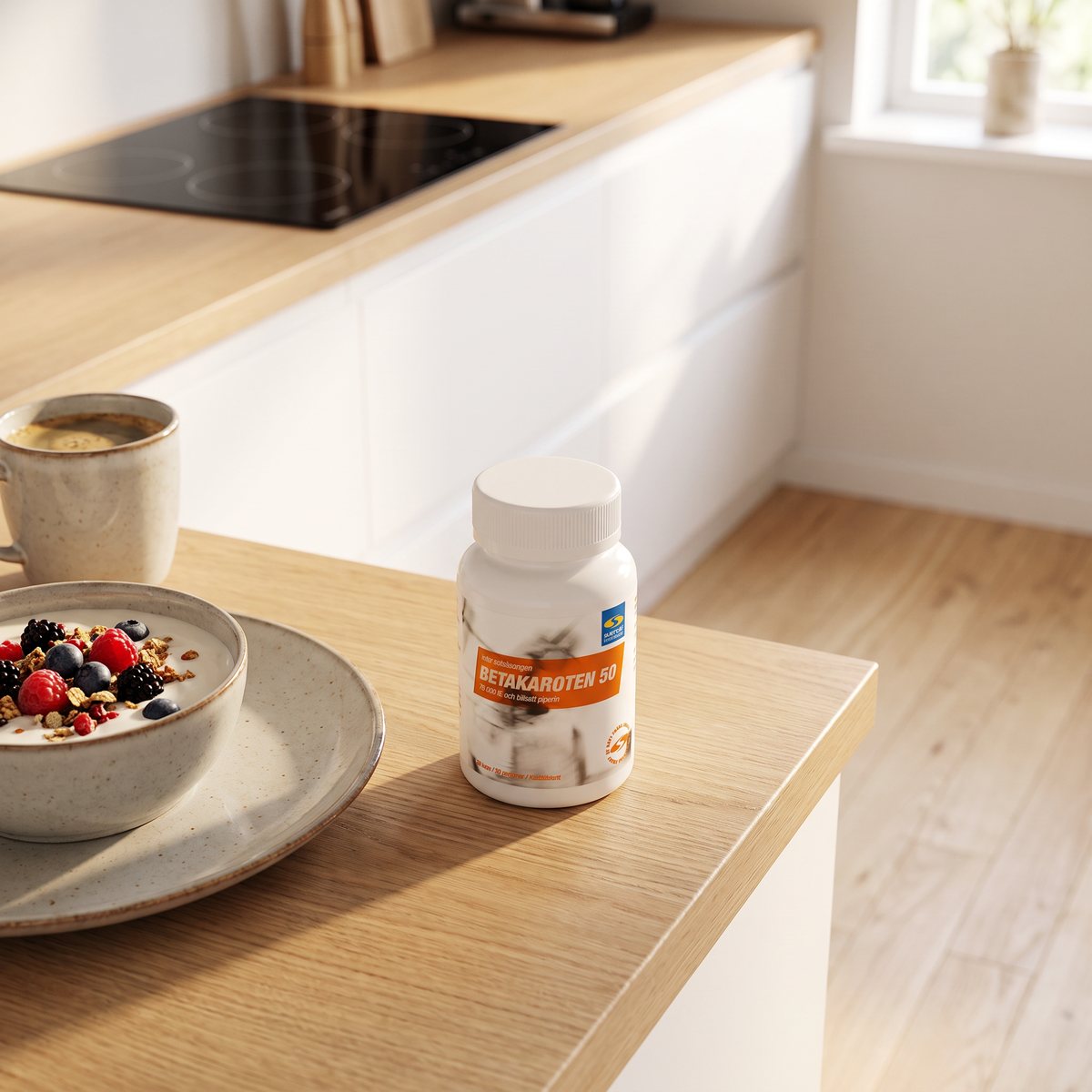 Vit burk med orange etikett, Core Betakaroten 50, på en köksbänk bredvid frukostyoghurt och kaffe i ett svenskt kök med induktionshäll