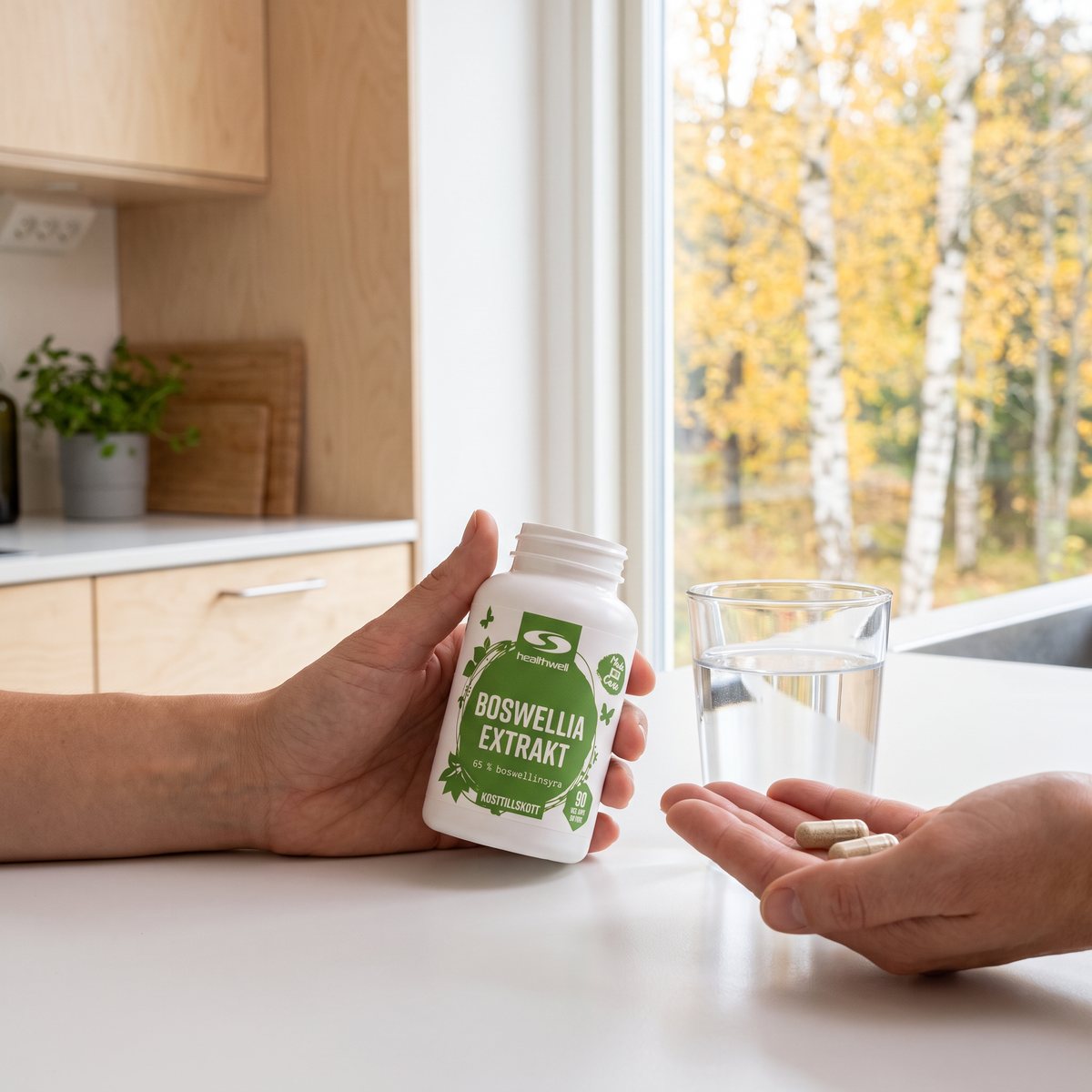 Healthwell Boswellia Extrakt-burk på en vit köksbänk i ett svenskt hem med ett glas vatten och kapslar i handen