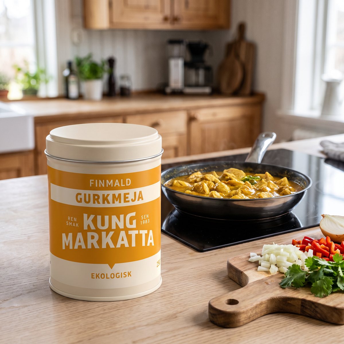 Kung Markatta Gurkmeja i plåtburk på en träbänk bredvid en panna med kycklingcurry på en induktionshäll i ett svenskt kök