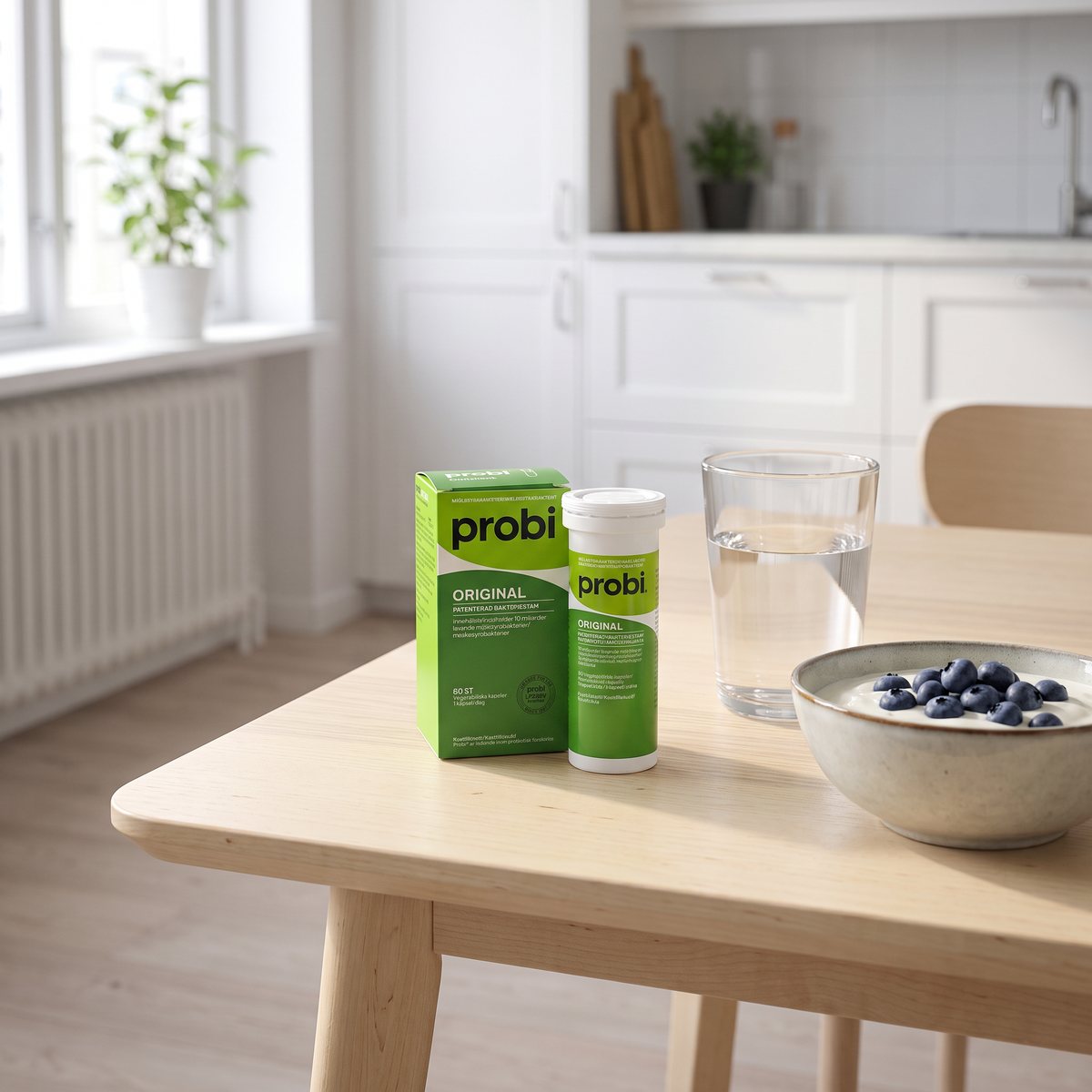 Probi Original-kartongen och burken på ett frukostbord i ett svenskt kök bredvid yoghurt och ett glas vatten