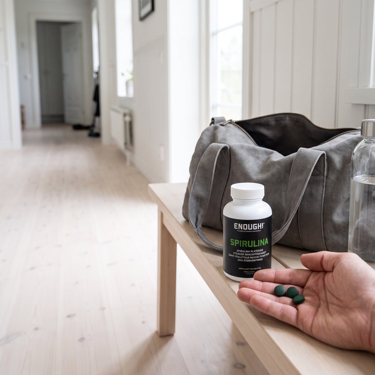 Enough Spirulina-burken på en träbänk i ett svenskt hemmagym efter träning, med vattenflaska och sportbag.