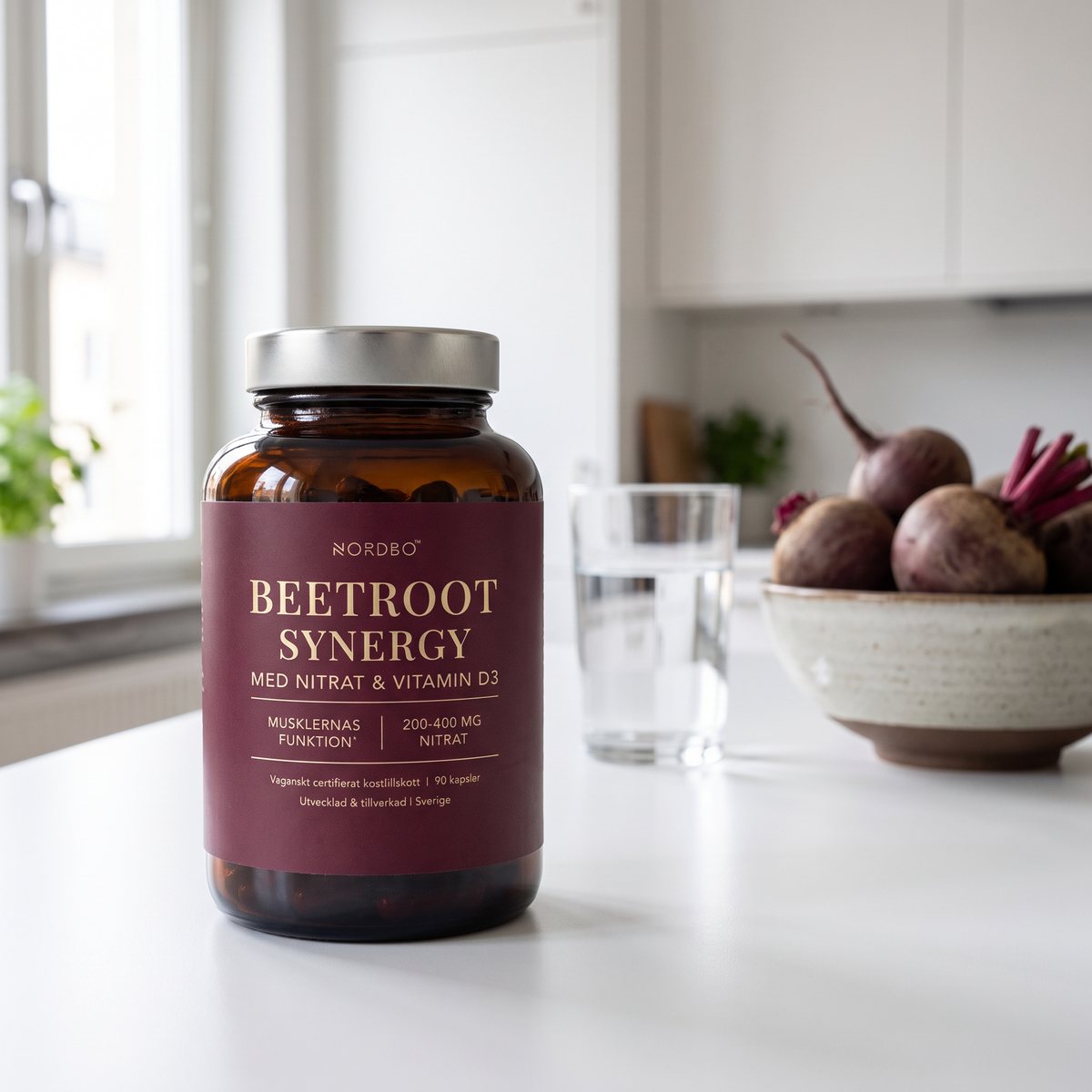 Brun glasburk med Nordbo Beetroot Synergy på en vit köksbänk i ett svenskt kök