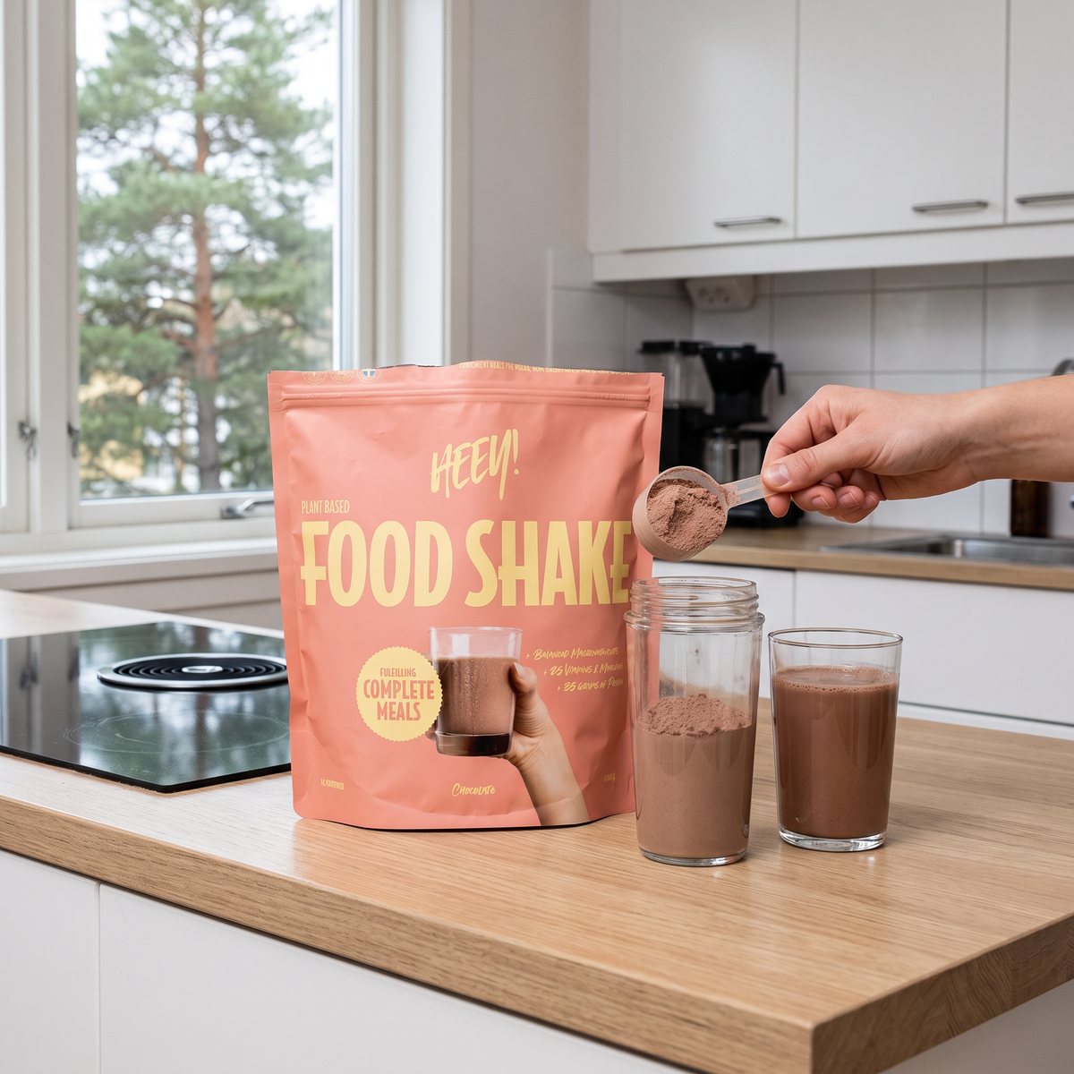 Heey! Food Shake Chocolate i rosa påse vid en shaker på köksbänken i ett svenskt kök