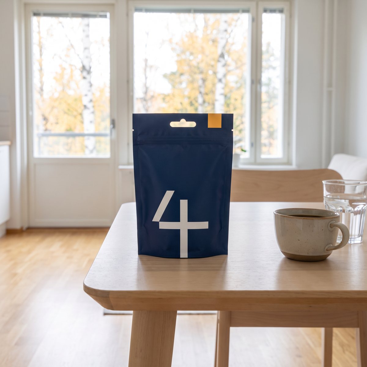 Marinblå påse med tabletter på ett björkbord i en svensk lägenhet
