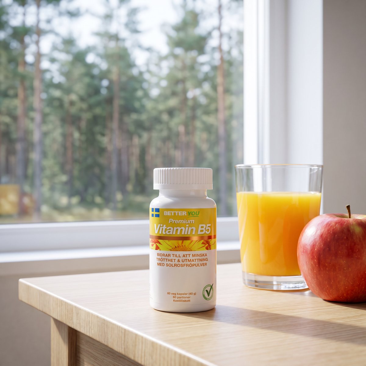 Vit tillskottsburk med gul etikett på ett köksbord i ett svenskt hem med apelsinjuice och äpple