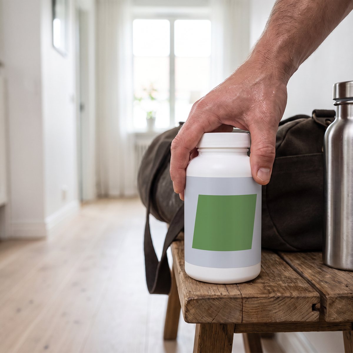 Core Vitamins Man-burken på en träbänk bredvid gymbag och vattenflaska i en ljus svensk hall