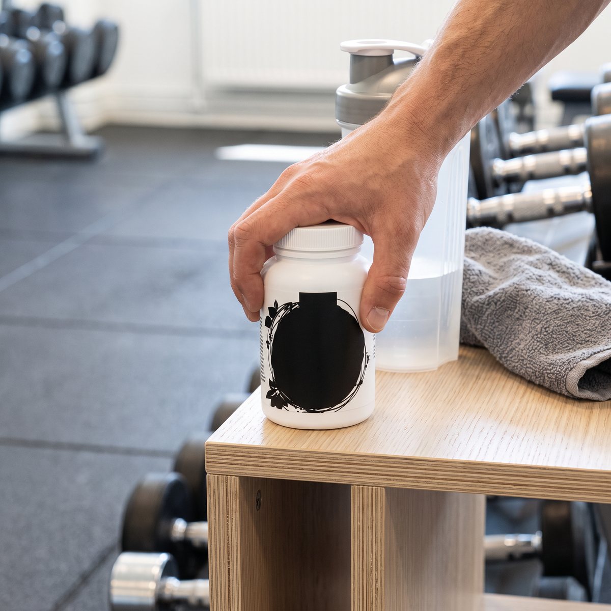 Burken Healthwell Multivitamin Sport Man på en hylla i ett svenskt gym