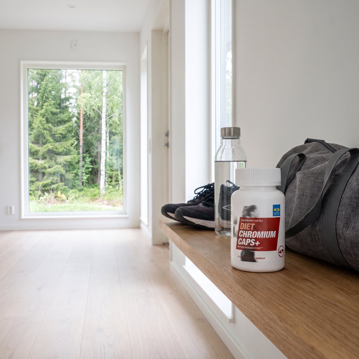 Diet Chromium Caps+ på en hylla i hallen bredvid vattenflaska, träningsskor och gymväska