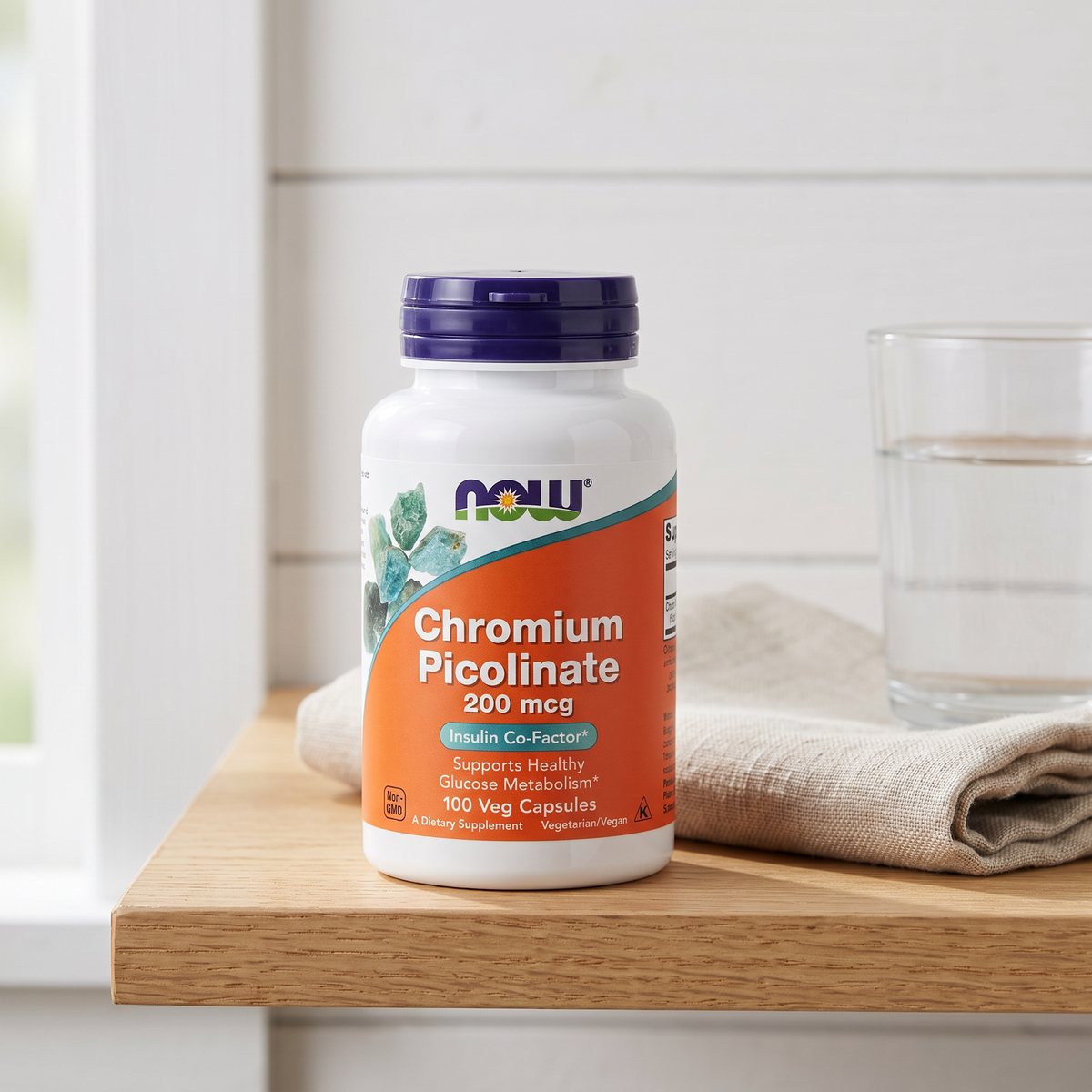 NOW Chromium Picolinate på en ljus trähylla bredvid linnehandduk och vattenglas i ett svenskt hem