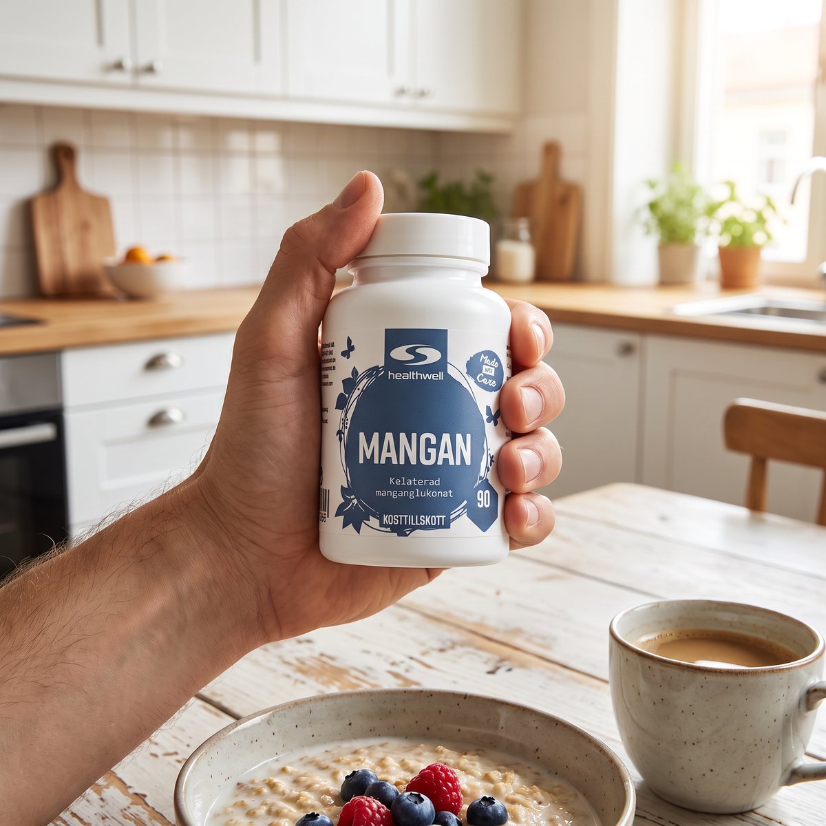 Hand som håller en burk Healthwell Mangan vid ett frukostbord med havregrynsgröt och kaffe i ett svenskt kök.