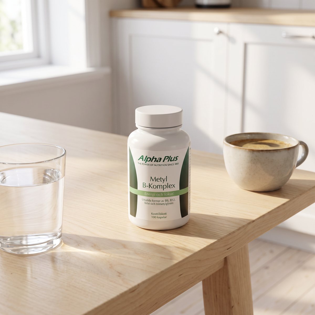 Burk med Alpha Plus Metyl B-komplex på ett träbord i ett ljust svenskt kök, bredvid ett glas vatten och en kopp kaffe