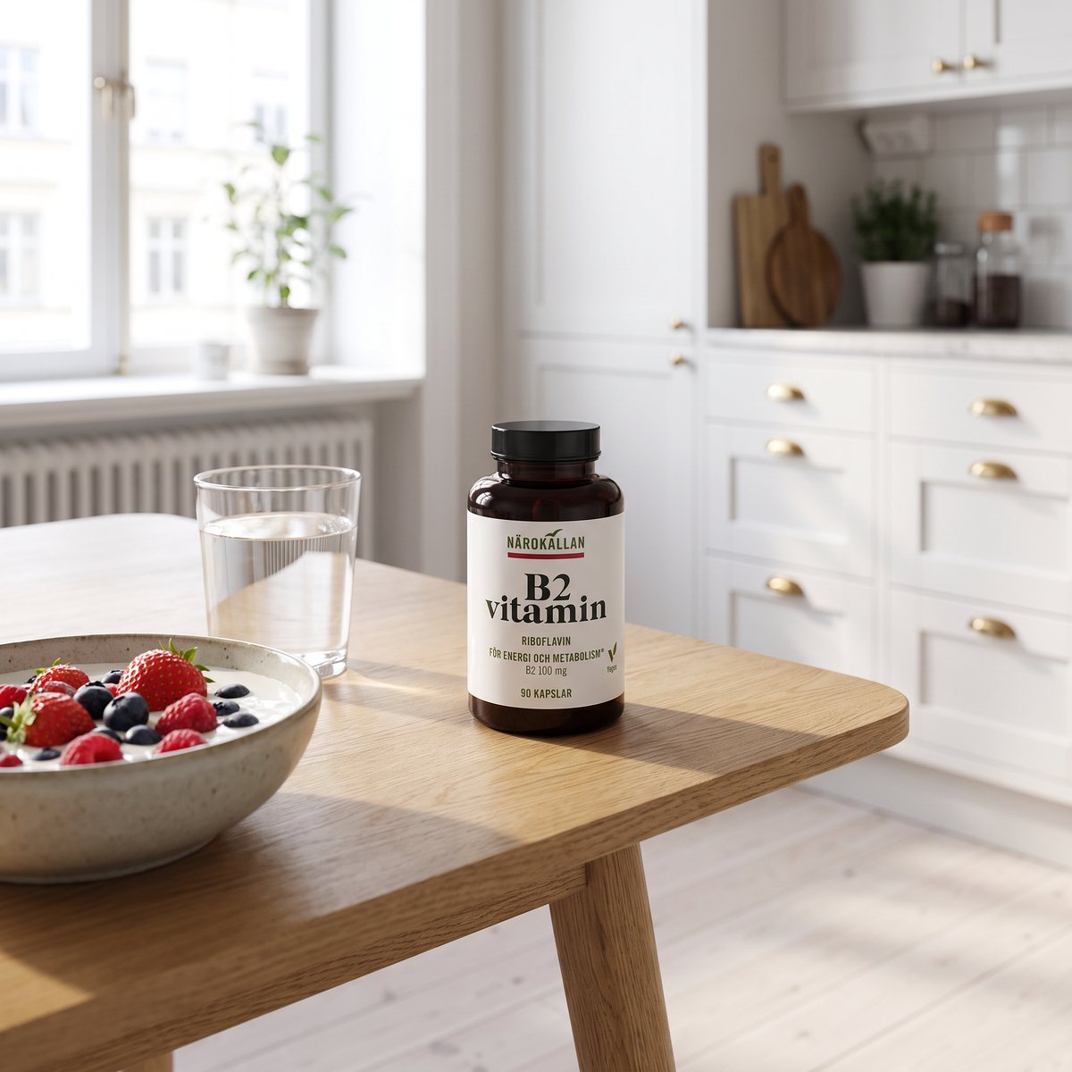 Burk med Närokällan B2 vitamin på ett ekbord bredvid filmjölk med bär och ett vattenglas i ett svenskt kök