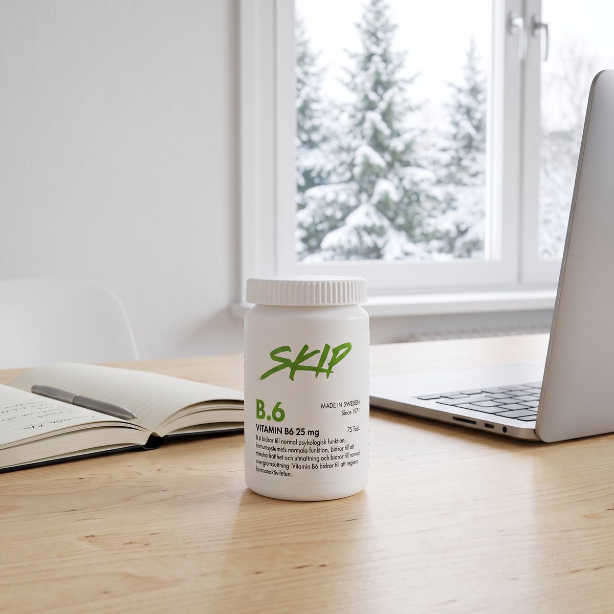 Skip Nutrition B6 på ett skrivbord i ett svenskt hemmakontor med snötäckta granar utanför