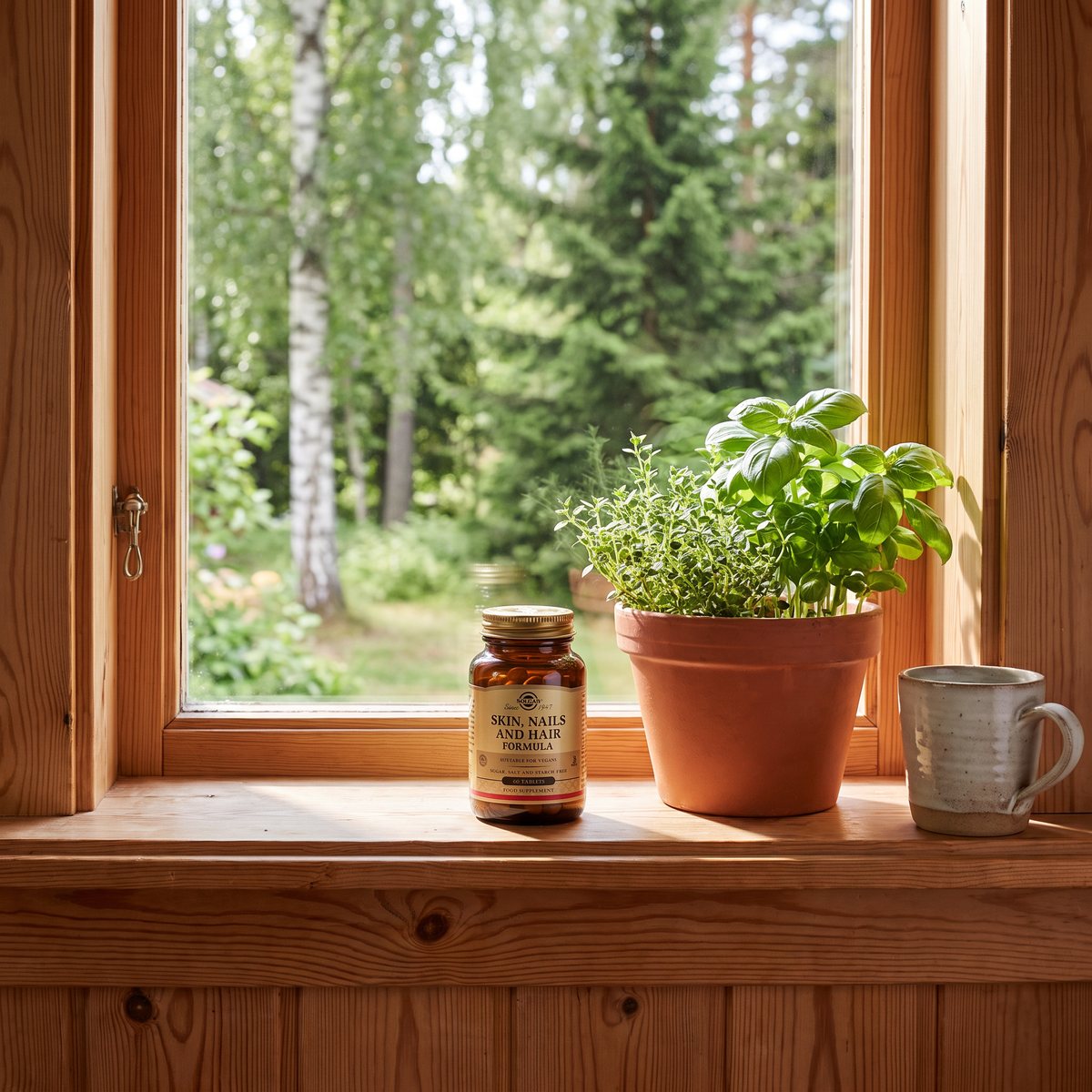 Solgar Skin, Nails & Hair Formula-burken på ett fönsterbräde av furu med björkar och granar utanför