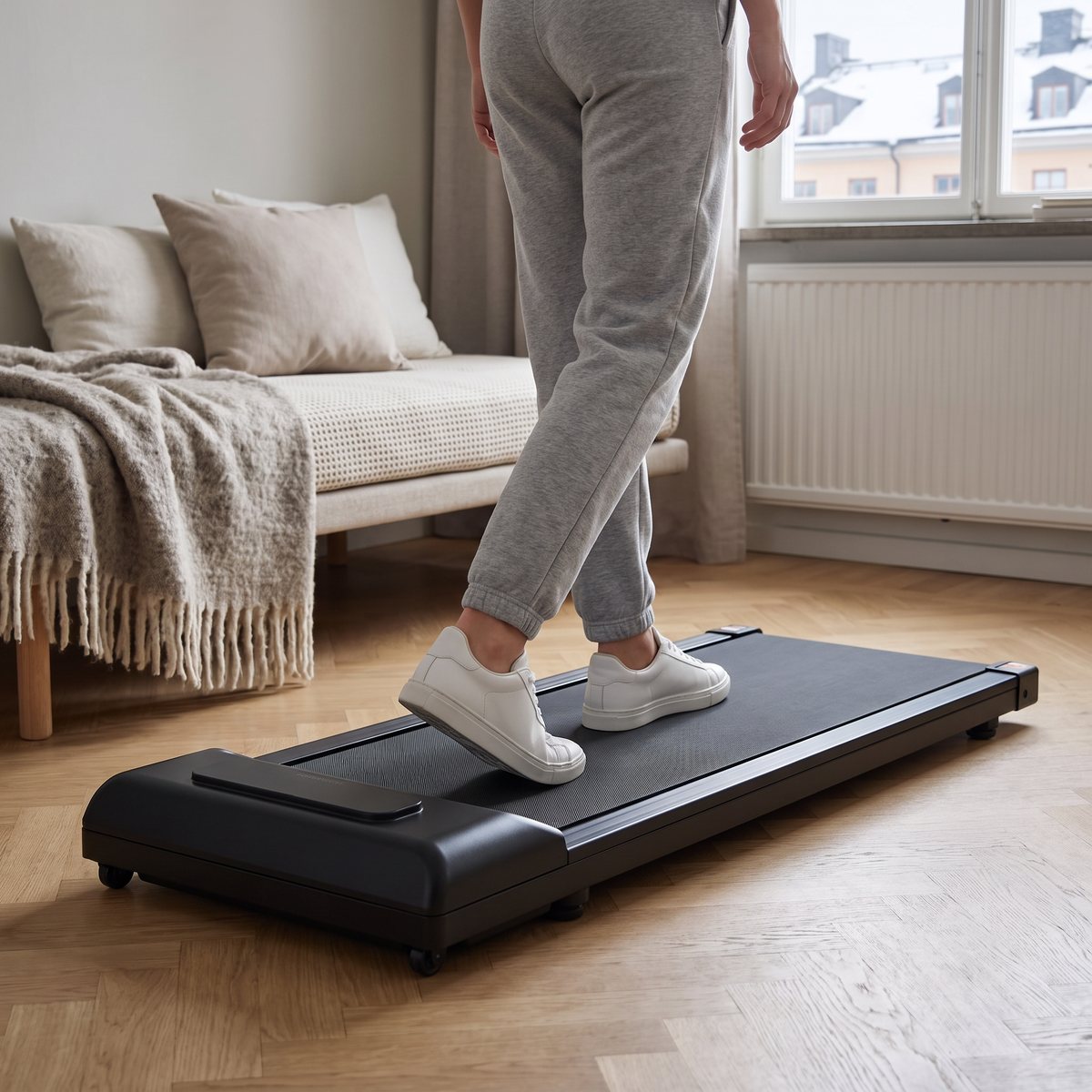Person promenerar på Titan Life Walking W10 i en liten svensk etta med dagbädd och snöiga tak utanför