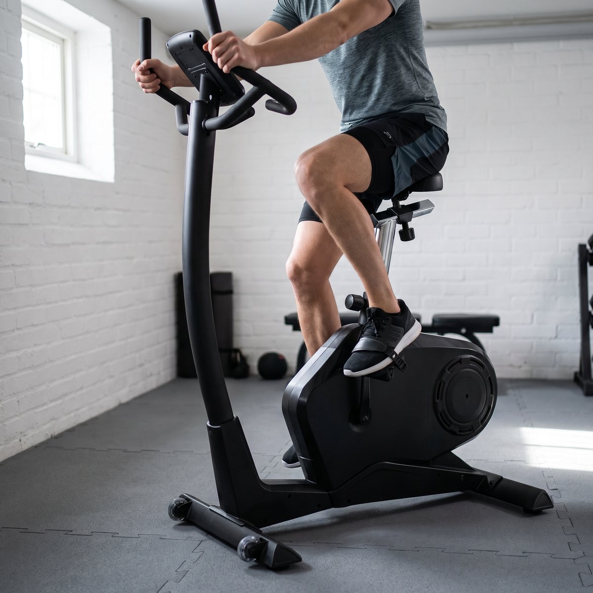 Master Fitness B40 ergometercykel i ett litet svenskt källargym med vitmålade tegelväggar och gummigolv
