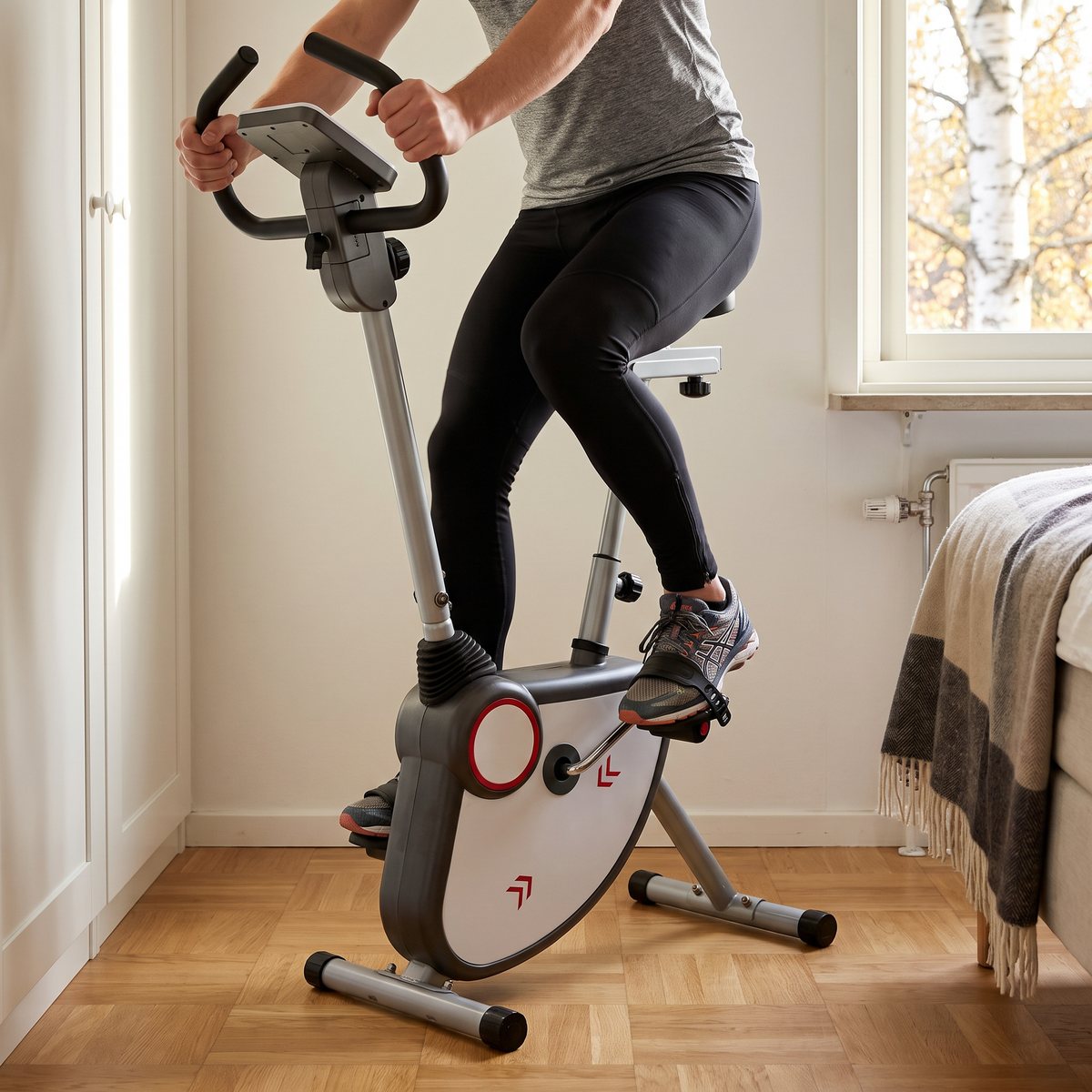 Person trampar en Toorx BRX-Flexi motionscykel i ett ljust sovrum med ekparkett, vit garderob och björk utanför fönstret
