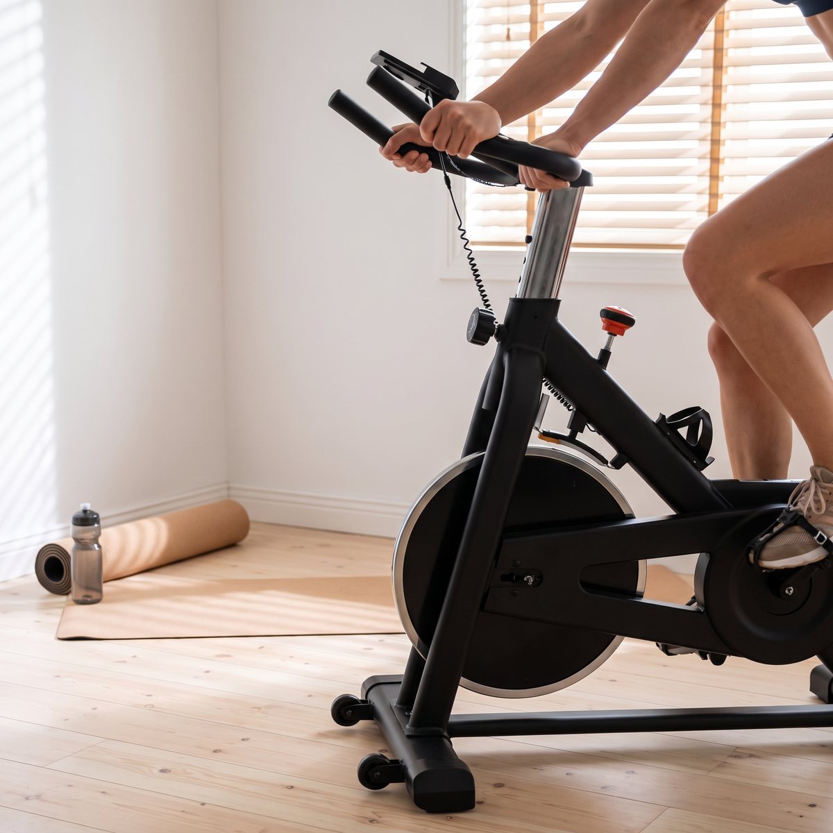 FitNord Racer 200 G2 spinningcykel i ett litet svenskt sovrum med vita väggar och tallgolv