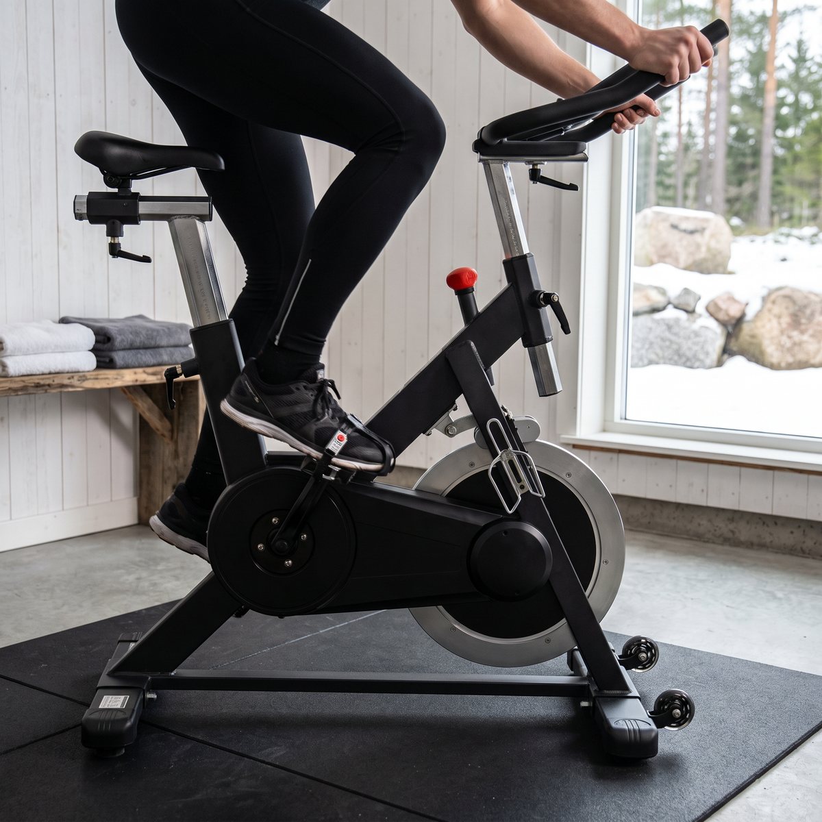 FitNord Racer 500 spinningcykel i ett svenskt garage som hemmagym med betonggolv och snöigt gårdsplan utanför