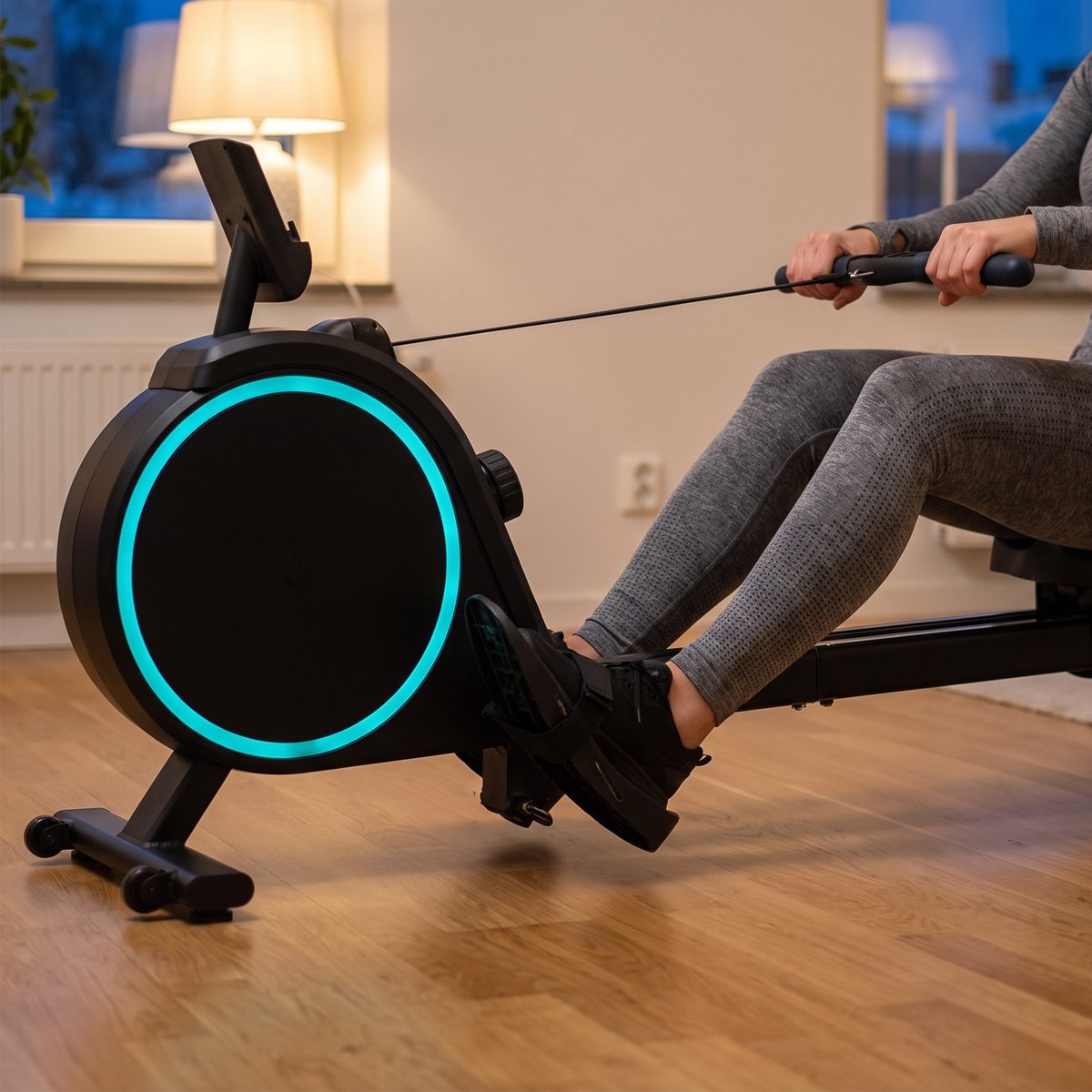 Titan LIFE R36 med turkos ljusring på svänghjulskåpan används en vinterkväll i ett vardagsrum med golvlampa