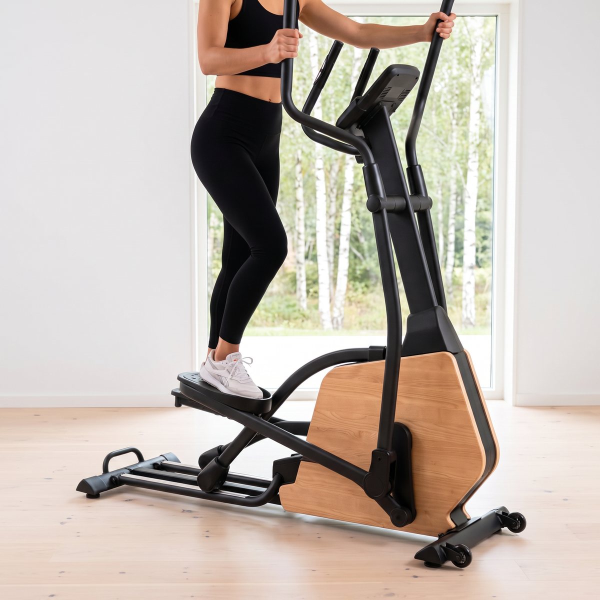 Hammer Sport CrossPace 5.0 NorsK med träkåpa används i ett ljust svenskt vardagsrum med björkar utanför fönstret