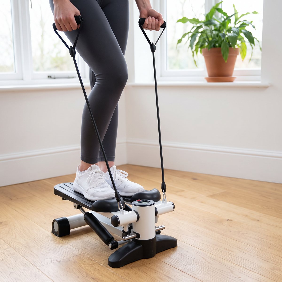 Titan LIFE Mini Stepper används av en person som håller i motståndsbanden i ett ljust svenskt hem med trägolv