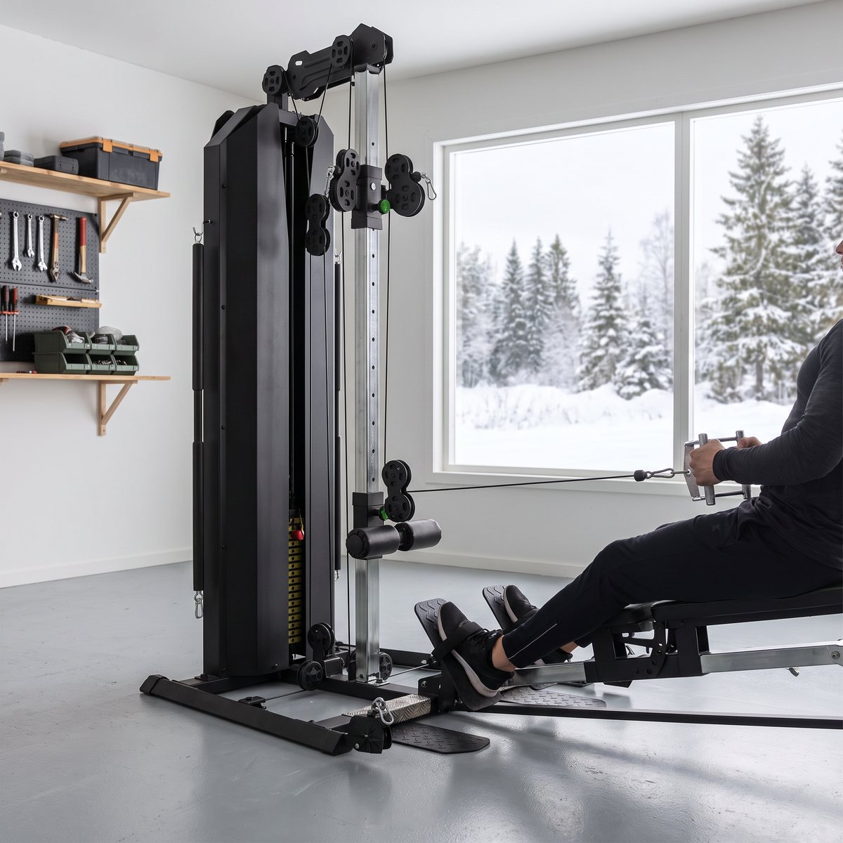 Tunturi HG80 i ett svenskt garagegym med snötäckta tallar utanför fönstret, använd för sittande rodd i låg vajer