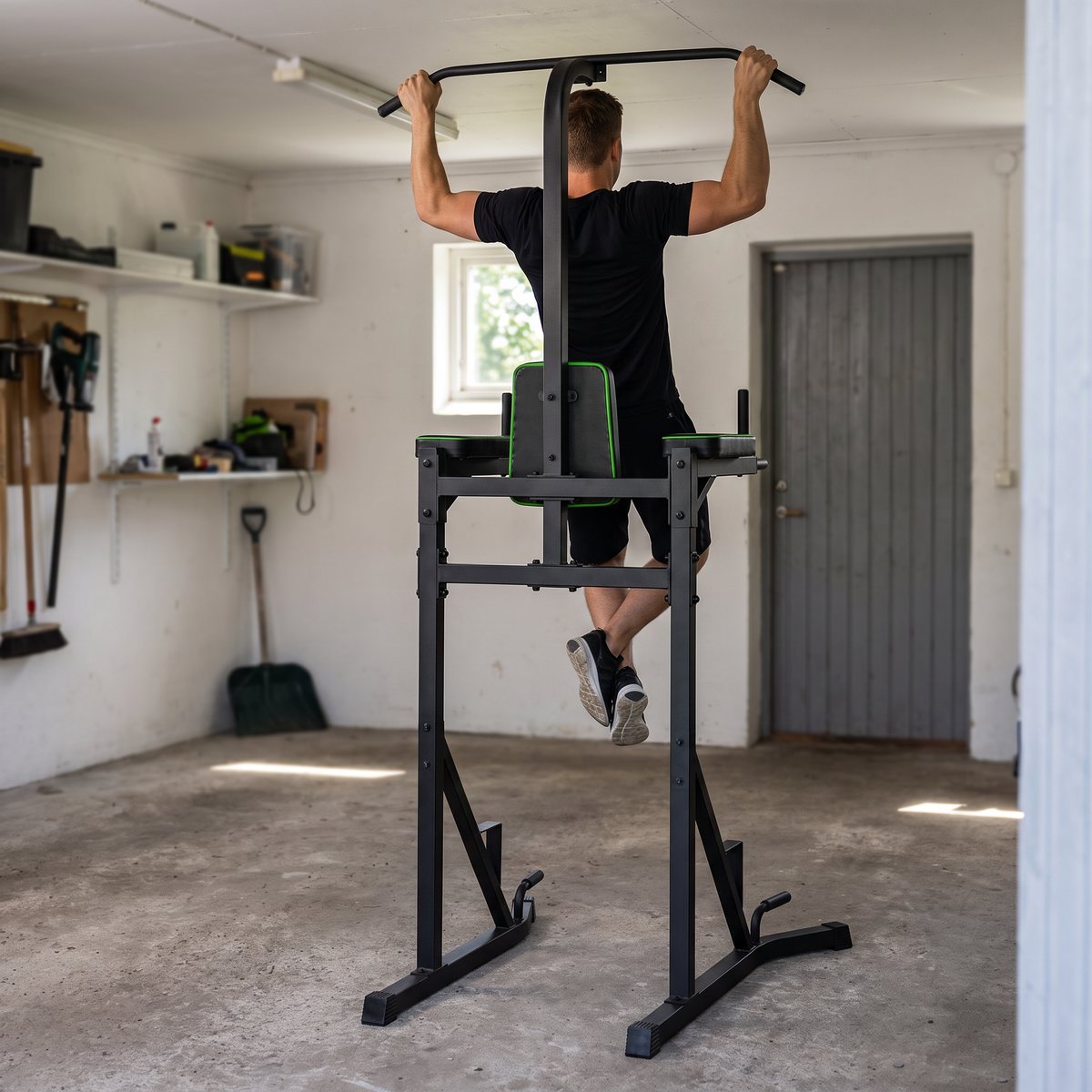 Tunturi PT20 Power Tower där en person gör pullups i ett svenskt garage med vitmålade väggar