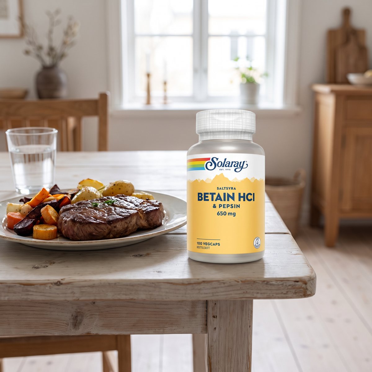 Burk med Solaray Betain HCl & Pepsin på ett ljust träbord bredvid en tallrik med biff och rostade grönsaker i ett svenskt hem
