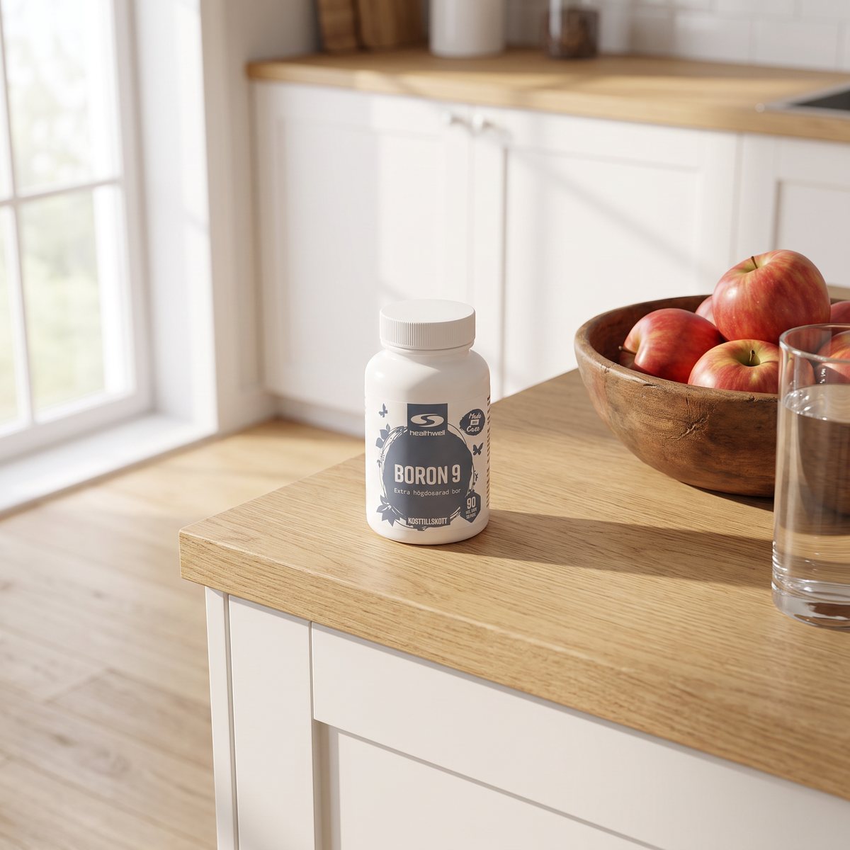 Healthwell Boron 9 mg på en köksbänk med äppelskål och vattenglas i ett svenskt kök