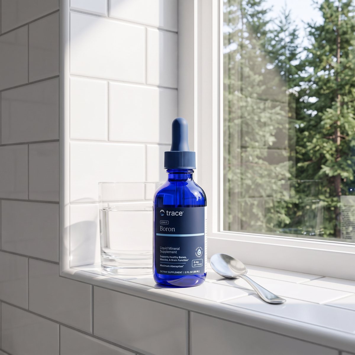 Droppflaska med Trace Minerals Liquid Ionic Boron på en kaklad fönsterbräda med utsikt mot tallar