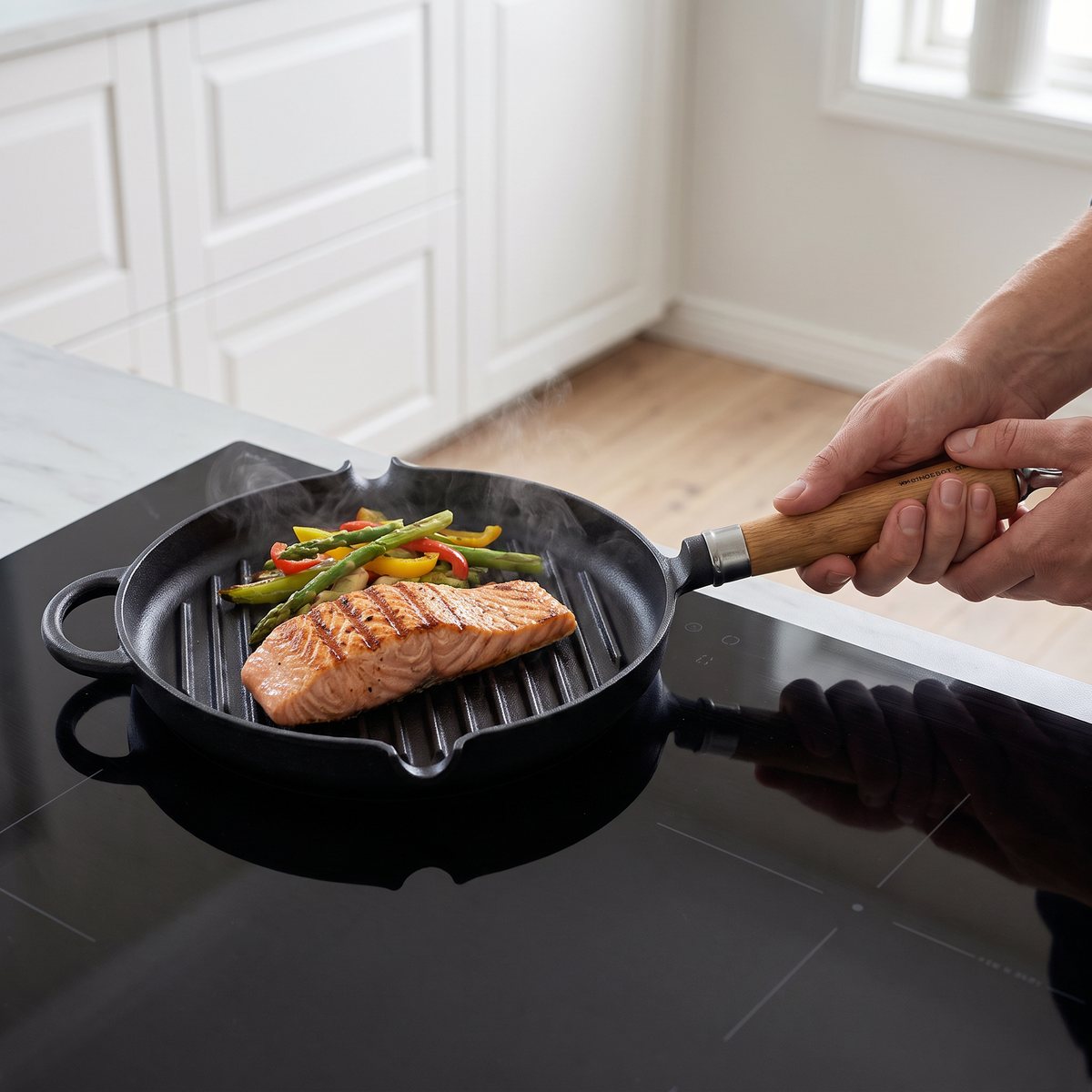 Svart grillpanna i gjutjärn med ekhandtag på en induktionshäll i ett svenskt kök, med lax och grönsaker som grillas